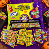 Halloween mini pouches of Fruit by the Foot, Gushers and Fruit Roll-Ups on a purple table