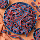 Pile of red and blue raspberry sour candy belts for parties and candy buffets