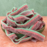 Watermelon Sour Belts in a bowl, chewy red and green sour candy strips coated in sour sugar