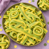 Pile of dill pickle sour candy belts for parties and candy buffets